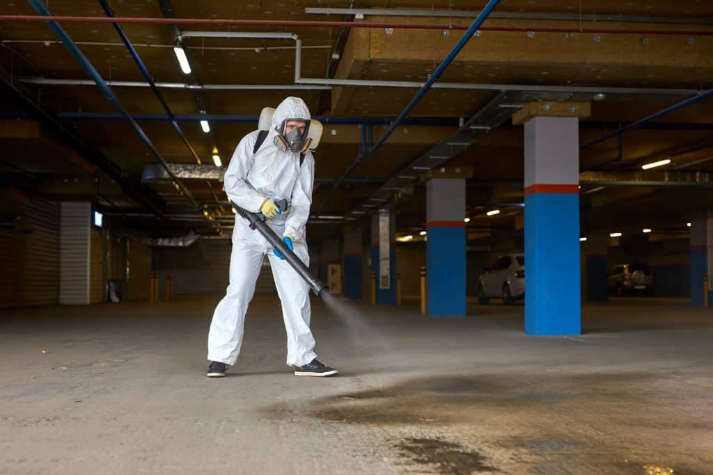 disinfecting parking garage with backpack fogger