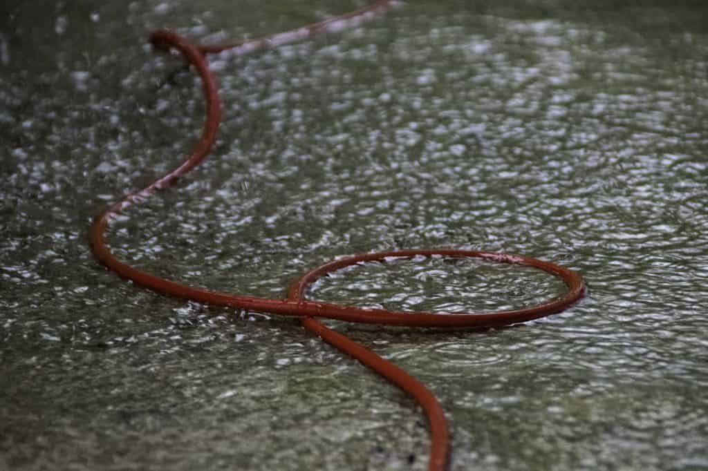 red extension cord in puddle during rain