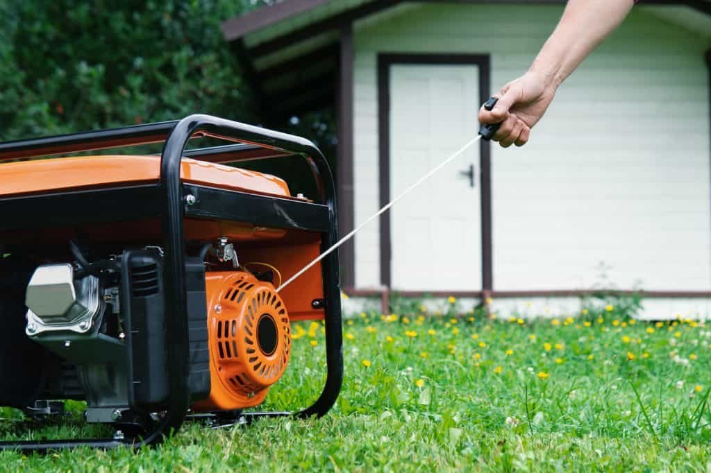 orange generator being started with a pull starter