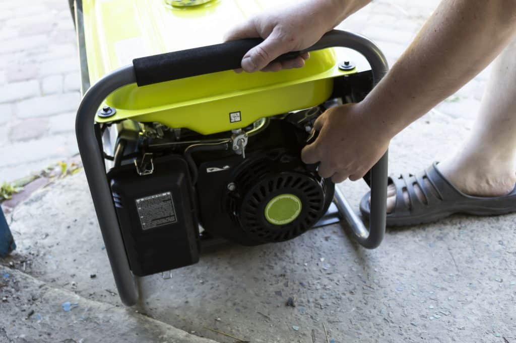 green generator being started by hand with pull starter